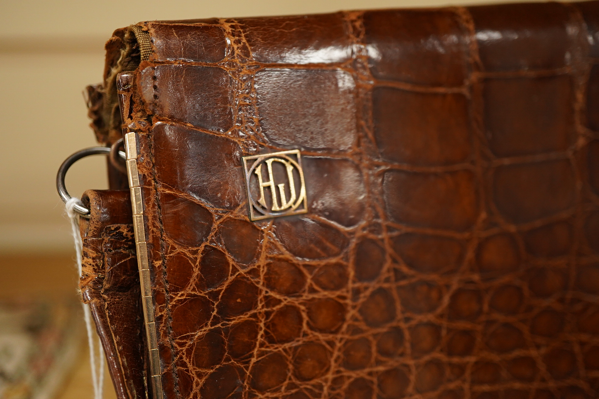 A stylish 1930's ladies 9ct gold mounted brown crocodile handbag, fitted with small wallet and mirror, 21.5cm wide x 15cm high. Condition - the corners to base, top and handle have wear, the silk lining has a small split